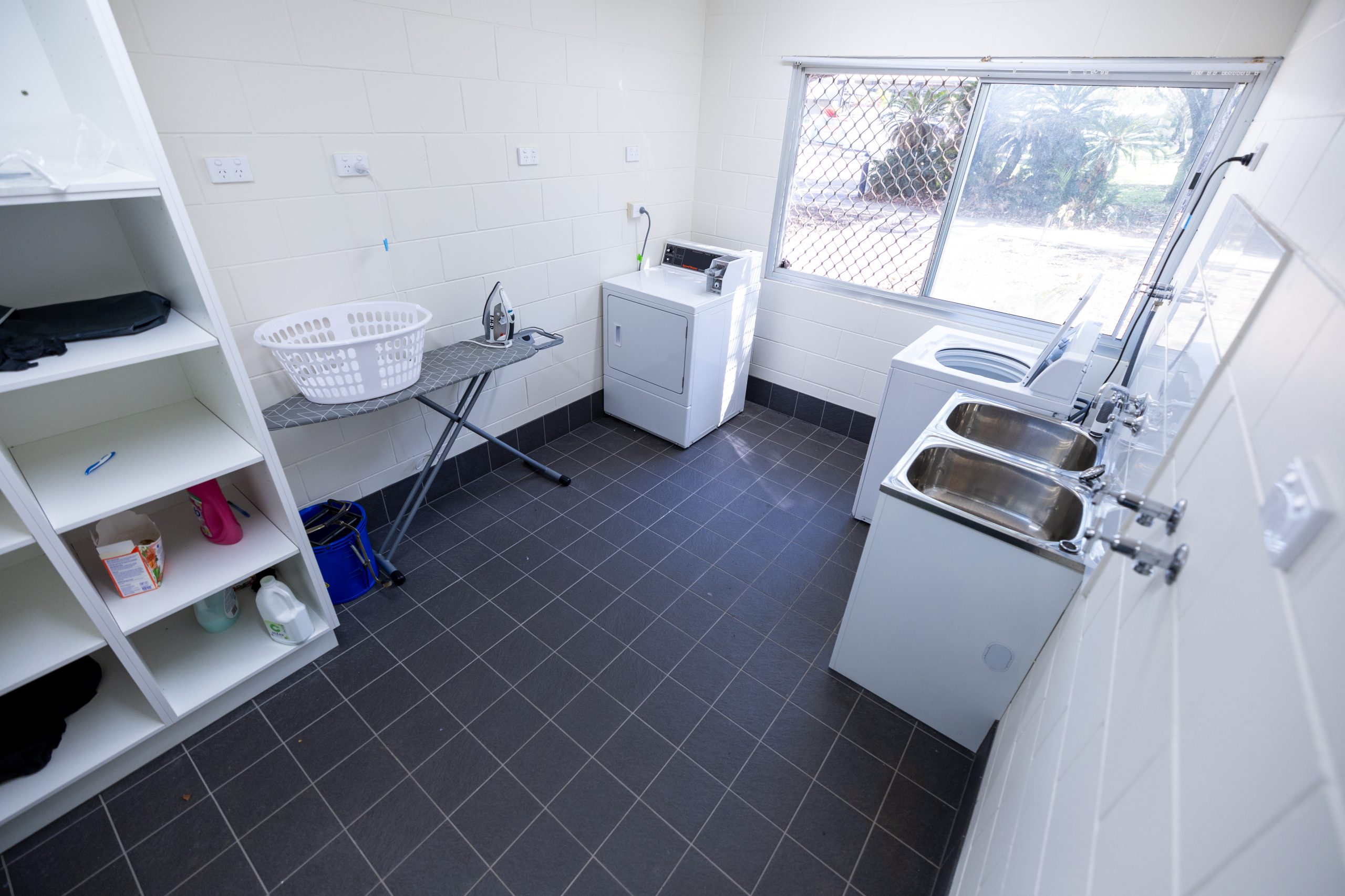 Shared laundry room, with machine, iron and sinks